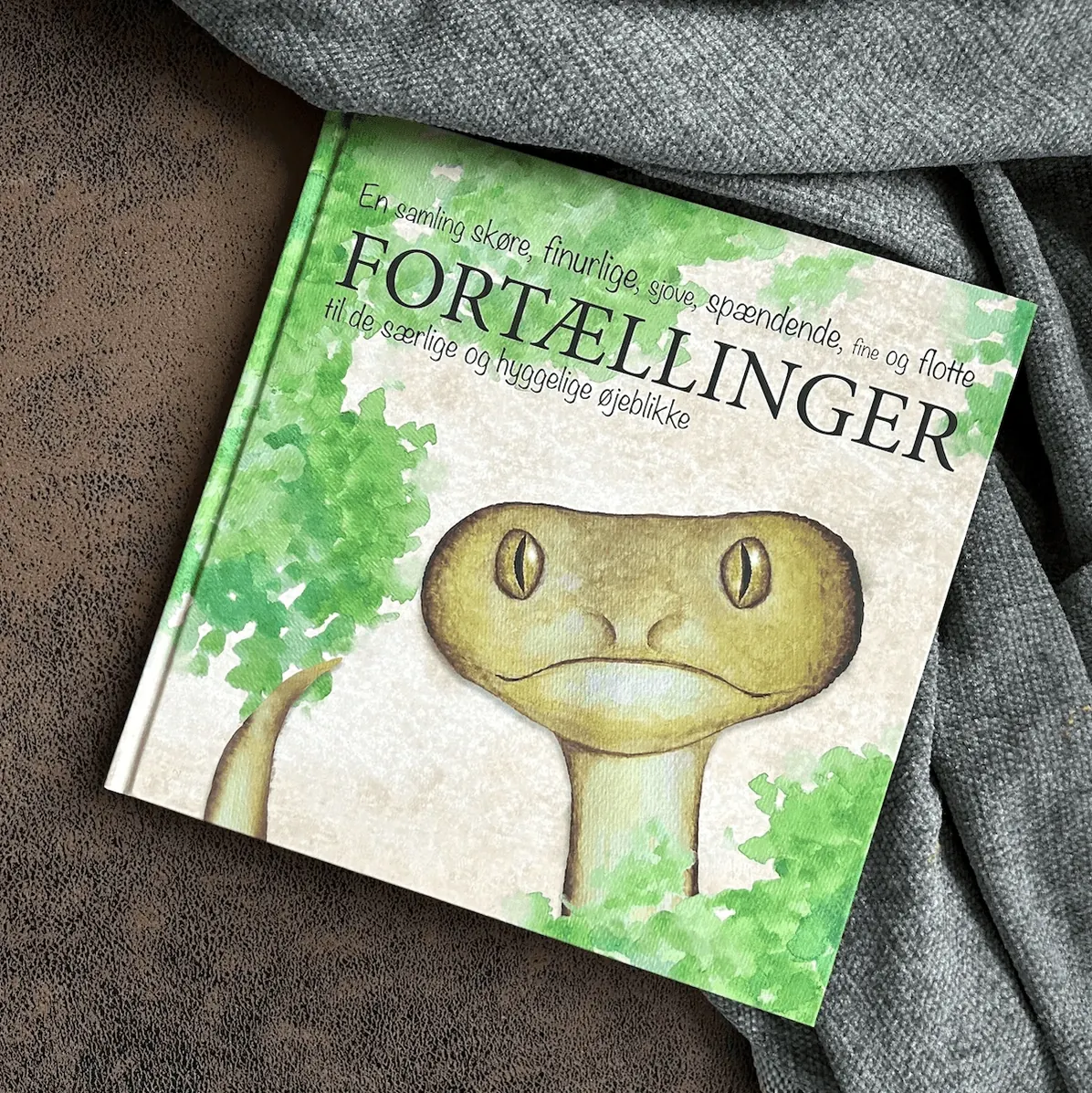 Bogen Fortællinger med slangen Egon på forsiden, liggende på et gråt tæppe